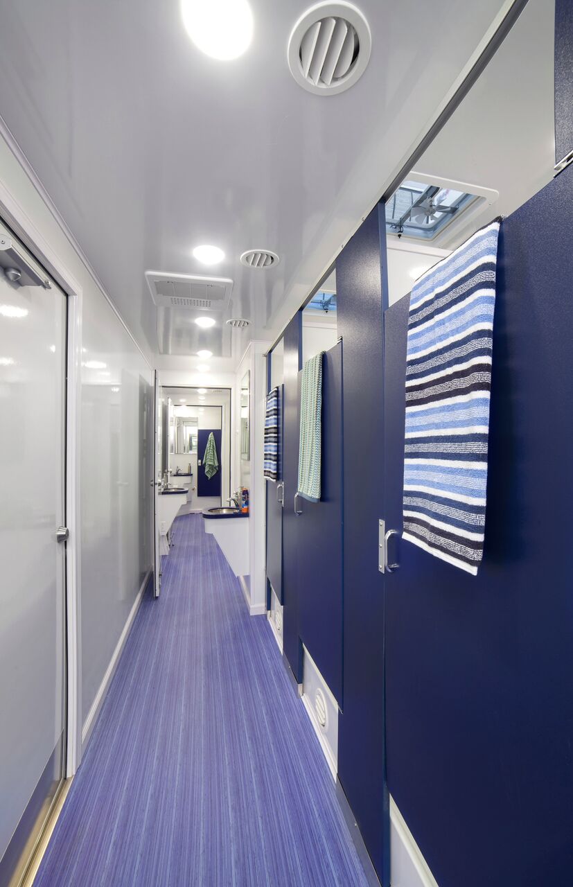 A zoomed in inside view of restroom stations with blue doors and colorful towels