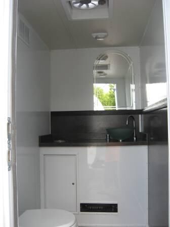 Side view of three station restroom trailer with three separate doors with signs
