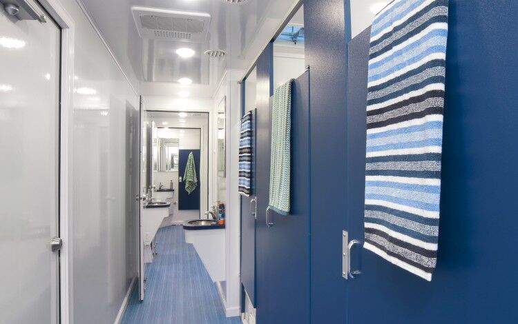 A zoomed in inside view of restroom stations with blue doors and colorful towels