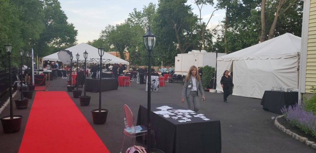 Red carpet leading to a VIP To Go restroom trailer at an evening fundraiser