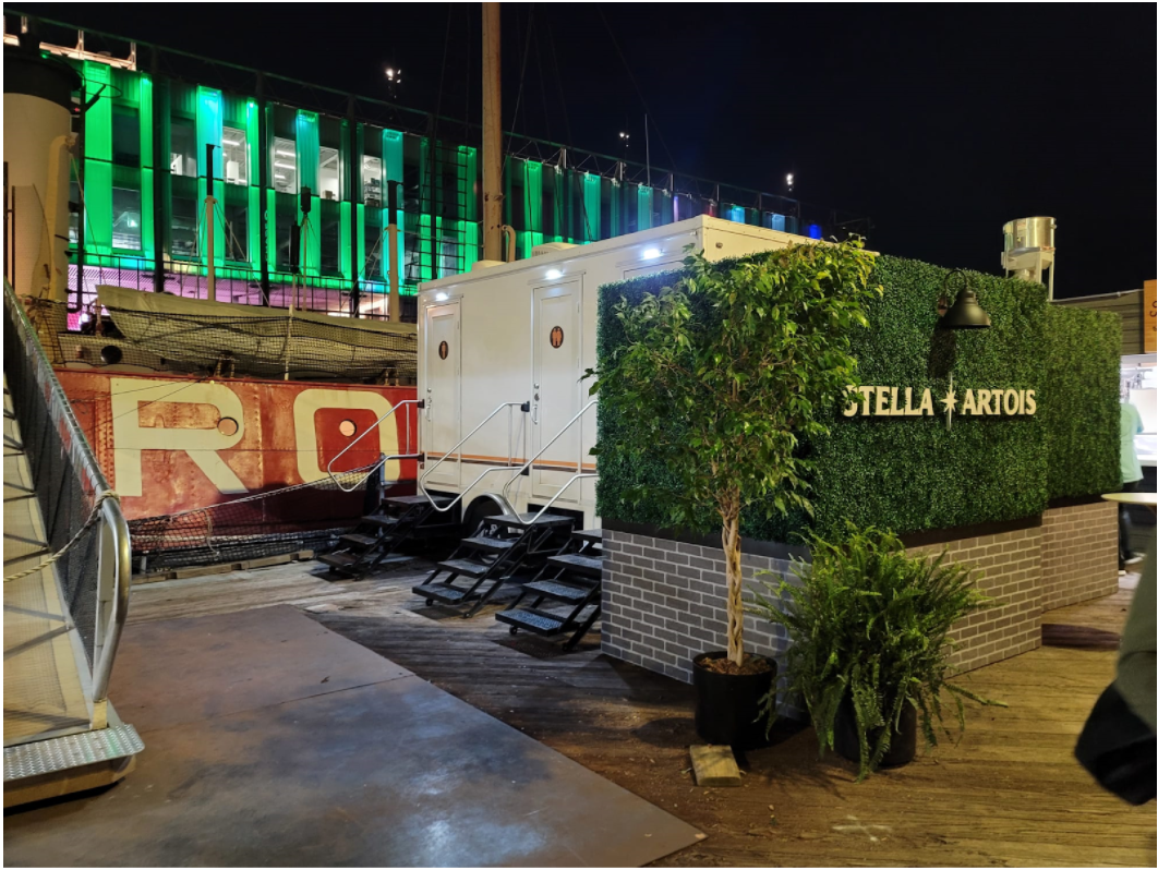 Portable bathroom at luxury outdoor lounge next to waterway