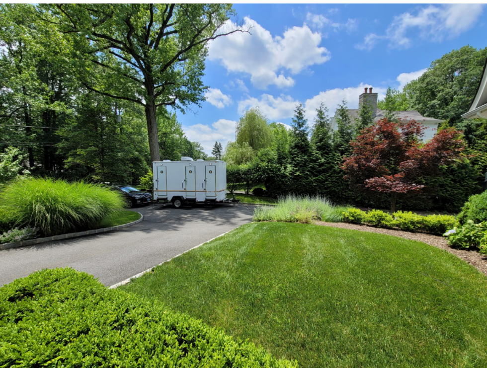 Restroom trailer surrounded by greenery and trees in New Hampshire