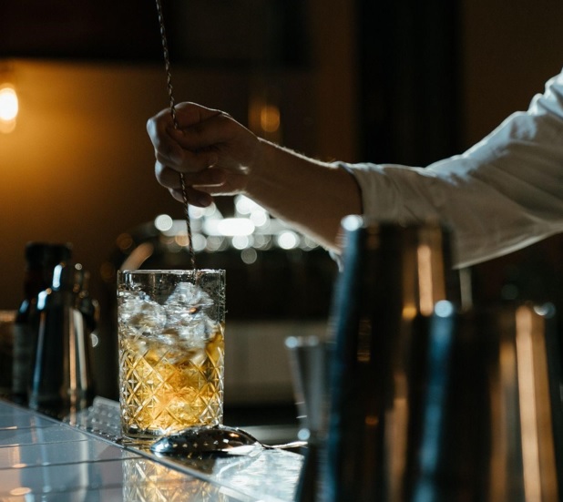 stirring a glass with cocktail and ice cubes