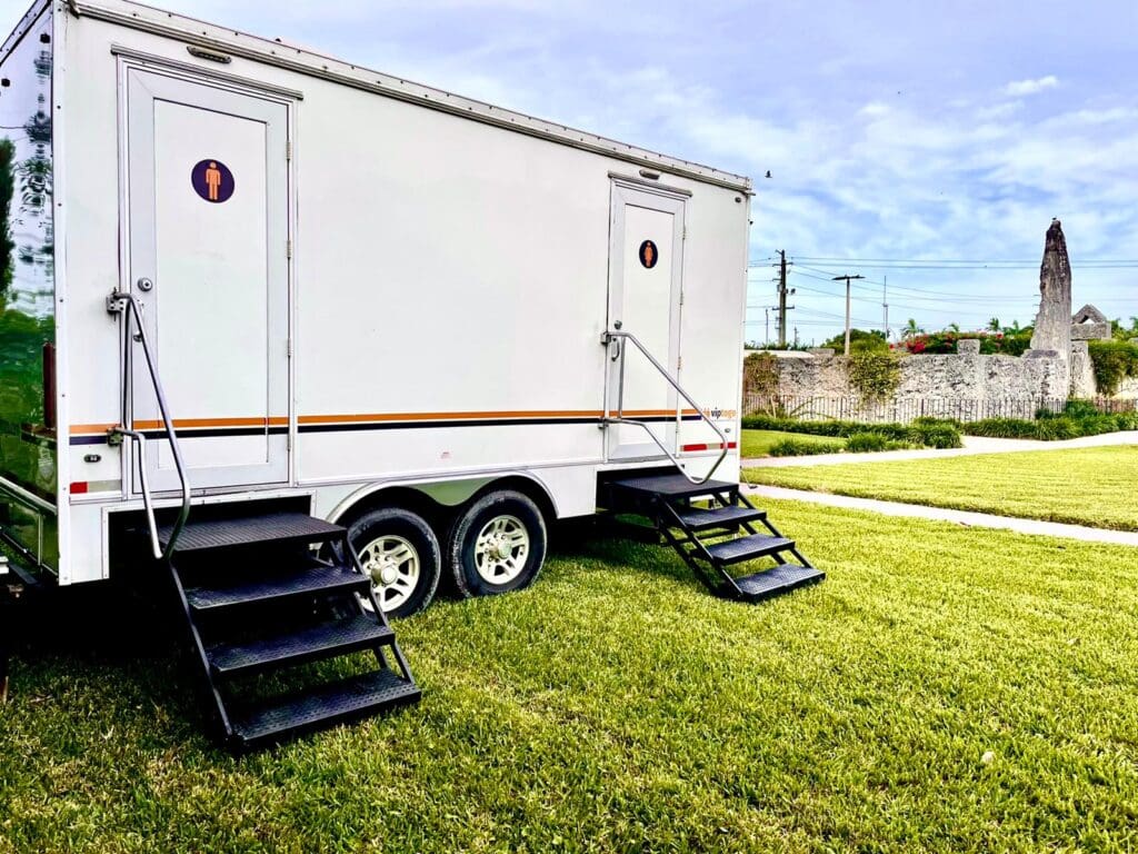 VIP To Go restroom trailer on a sunny lawn in Homestead, Florida