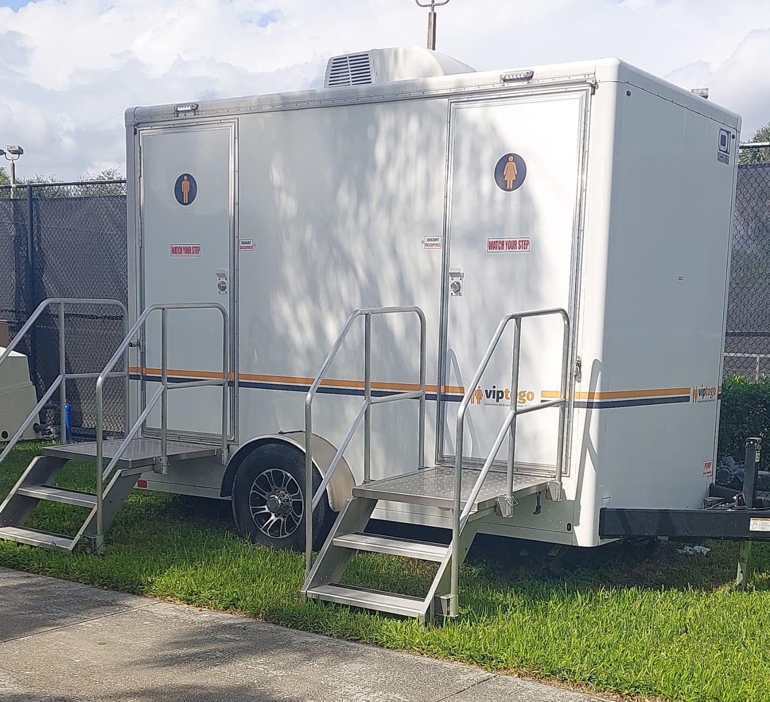 restroom trailer rental parked on grass