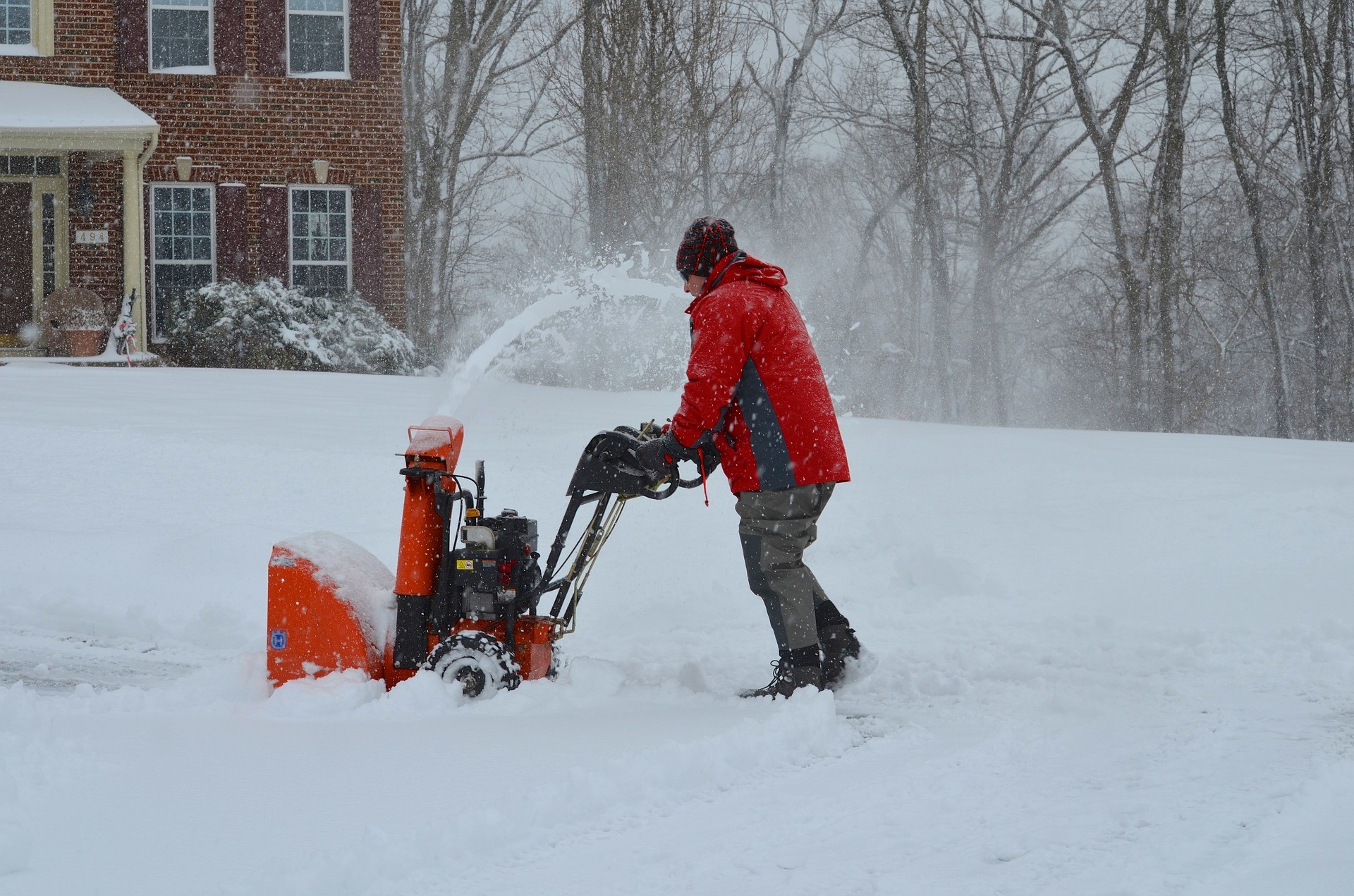 man pushing snow blower outside home man pushing snow blower outside home