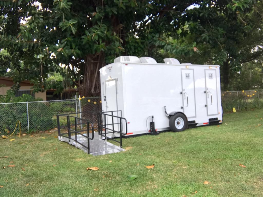 ADA-accessible restroom trailer rental parked on grass