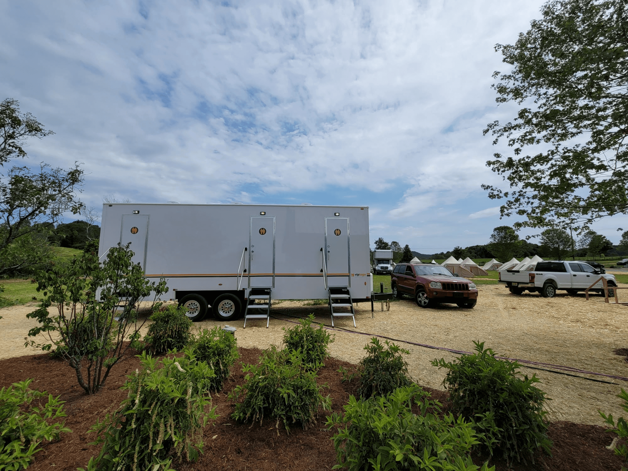 temporary portable shower trailer parked at camping site