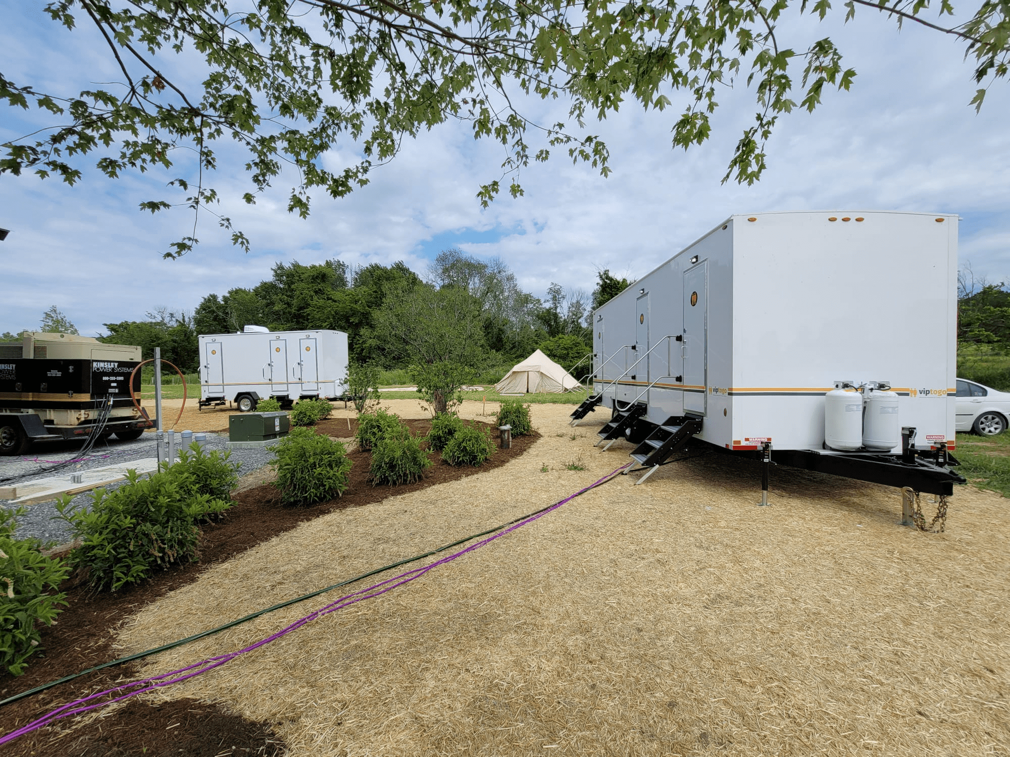 view of portable shower rental trailers at campsite
